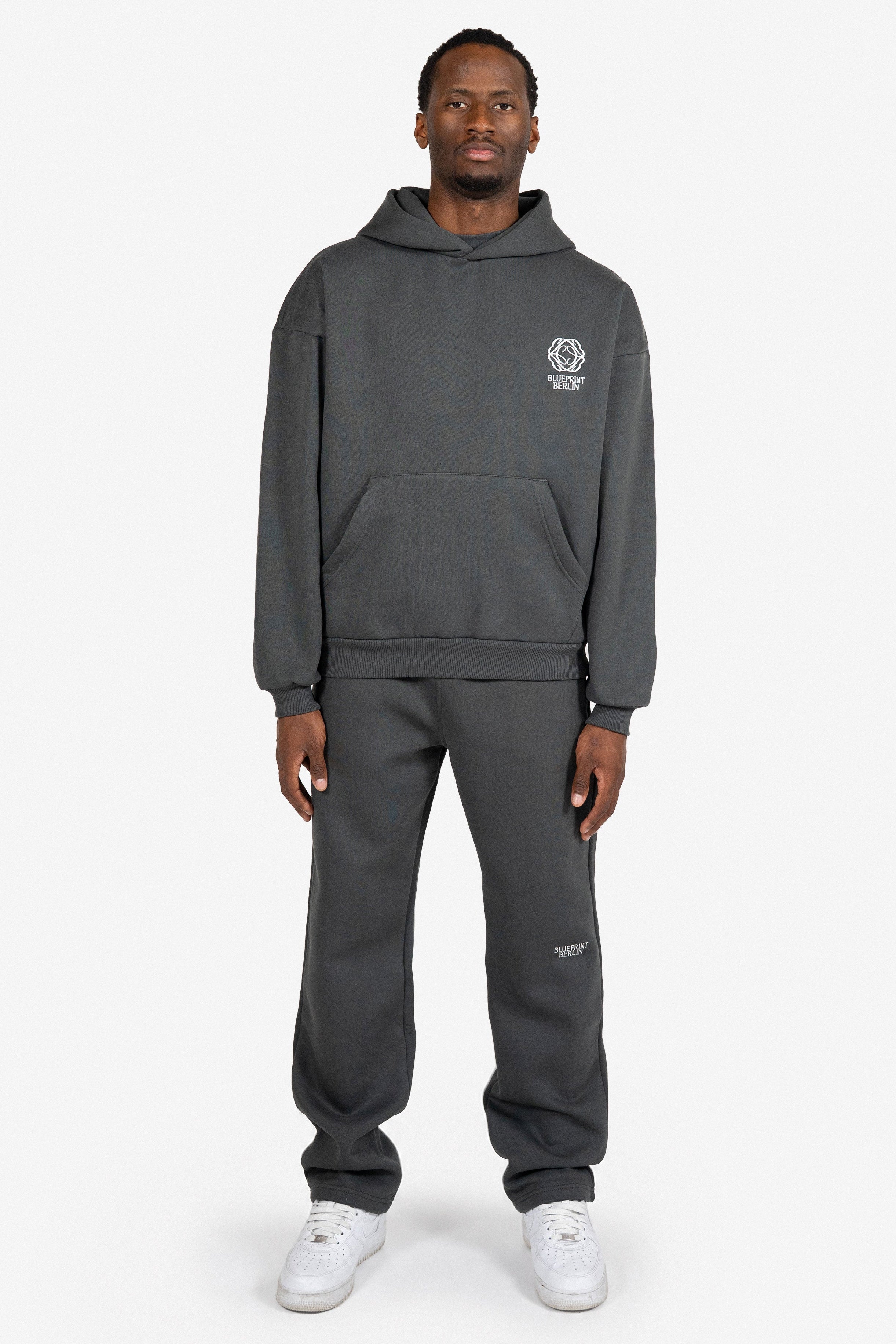 Mann trägt Volcanic Ash Set – Oversize Hoodie und Pants von Blueprint Berlin